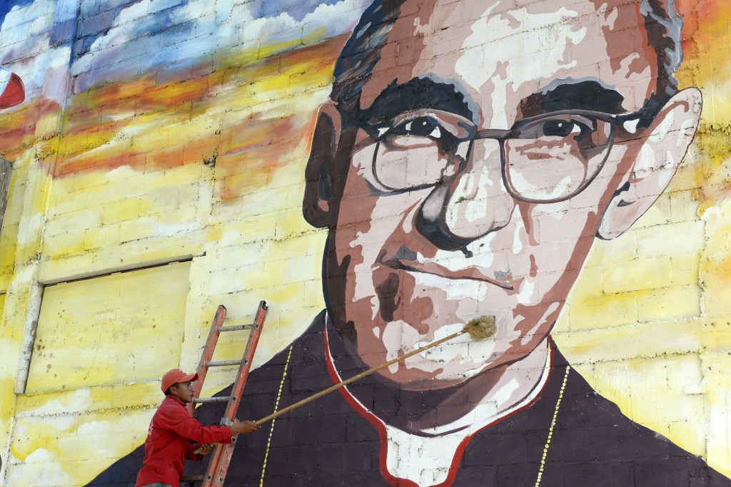 Un hombre limpia un mural dedicado a monseñor Romero. (Crédito: Marvin RECINOS/AFP/Getty Images)