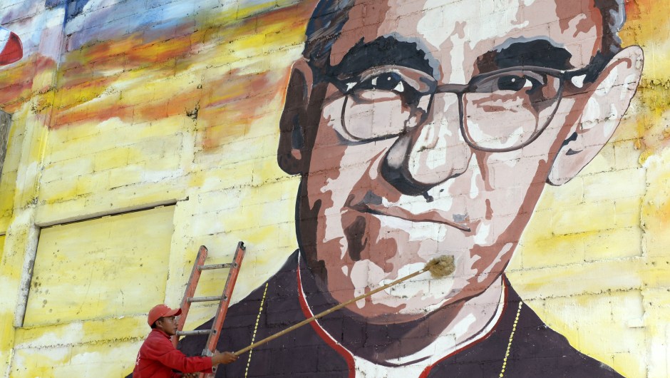 Un hombre limpia un mural dedicado a monseñor Romero. (Crédito: Marvin RECINOS/AFP/Getty Images)