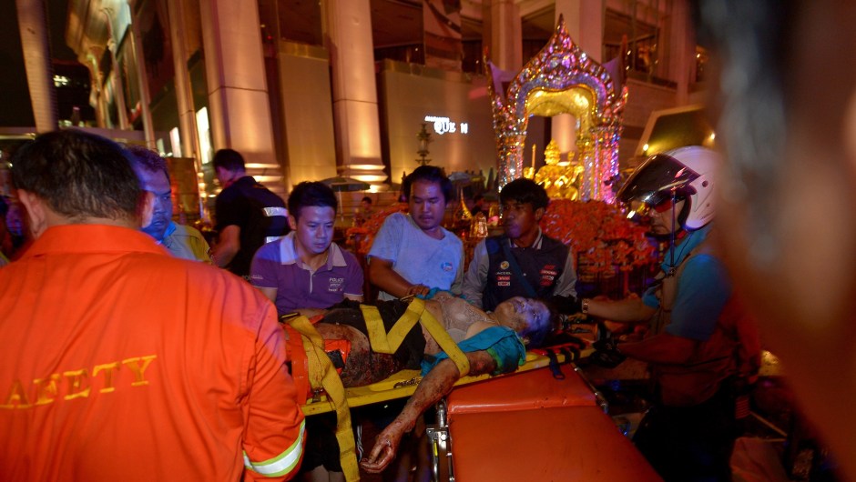 Thai rescue workers transport an injured person (C) after a bomb exploded outside a religious shrine in central Bangkok late on August 17, 2015 killing at least 10 people and wounding scores more. Body parts were scattered across the street after the explosion outside the Erawan Shrine in the downtown Chidlom district of the Thai capital. AFP PHOTO / PORNCHAI KITTIWONGSAKUL (Photo credit should read PORNCHAI KITTIWONGSAKUL/AFP/Getty Images)