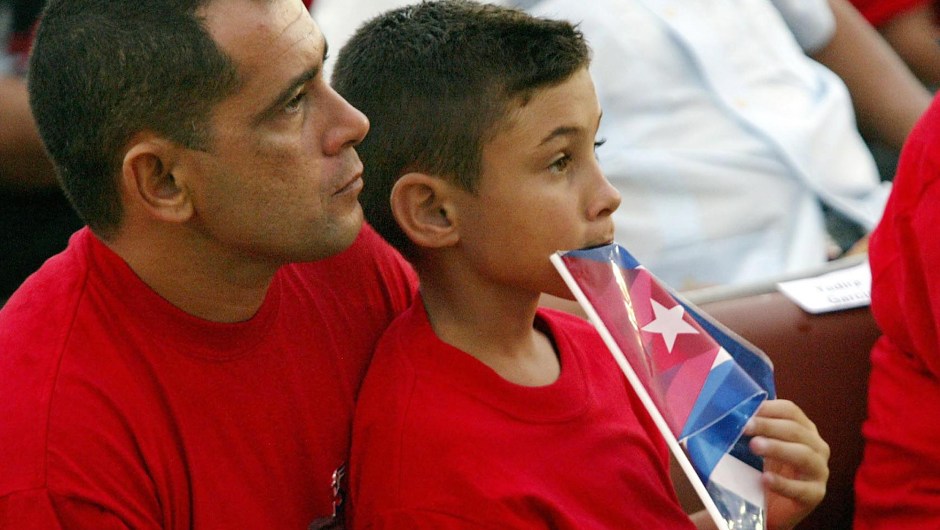 El niño balsero Elián González junto a su padre en una ceremonia el 26 de julio de 2003 para celebrar el 50 aniversario del asalto al cuartel Moncada. Crédito: ADALBERTO ROQUE/AFP/Getty Images.