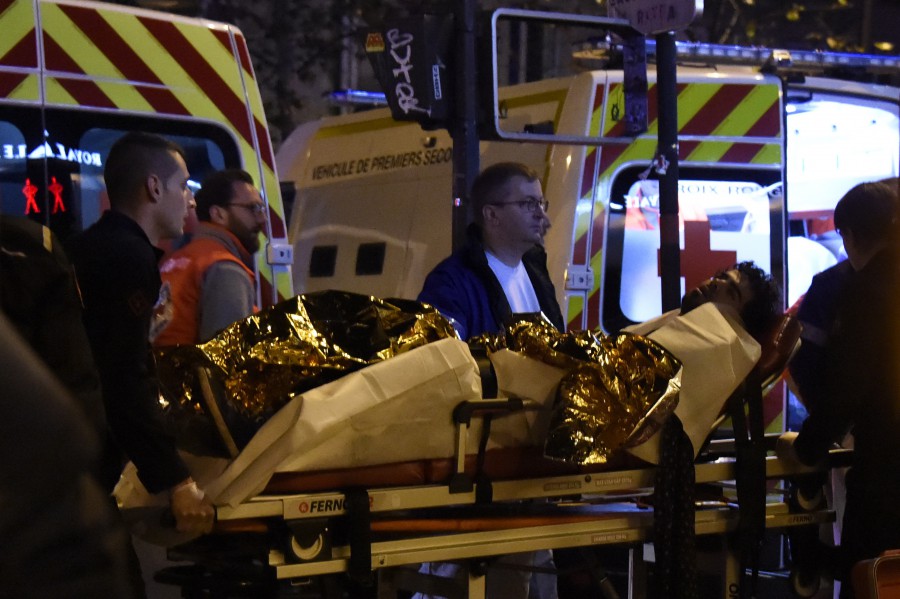 Paramédicos transportan a un espectador herido, quien se encontraba dentro de la sala de conciertos donde fueron tomados como rehenes cientos de personas (AFP/Getty Images).