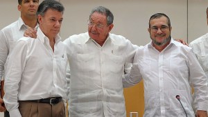 PAZ RECONCILIACIÓN COLOMBIA Cuban President Raul Castro (C) embraces Colombian President Juan Manuel Santos (L) and the head of the FARC guerrilla Timoleon Jimenez, aka Timochenko (R), during a meeting in Havana on September 23, 2015. The Colombian government and FARC rebels announced a key breakthrough in their nearly three-year peace talks Wednesday with the signing of a deal on justice for crimes committed during the five-decade conflict. The deal includes the creation of special courts and a broad amnesty, though this will not cover "crimes against humanity, serious war crimes" and other offenses including kidnappings, extrajudicial executions and sexual abuse, said officials from Cuba and Norway, the guarantors in the talks. AFP PHOTO / Yamil Lage (Photo credit should read YAMIL LAGE/AFP/Getty Images)