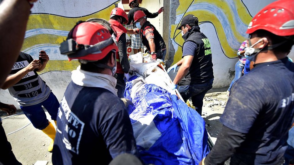 Rescuers personnel carry a corpse in Pedernales, Ecuador on April 19, 2016. At least 350 people were killed when a powerful earthquake struck Ecuador on Saturday, destroying buildings and a bridge and sending terrified residents scrambling from their homes, authorities said Sunday. / AFP / RODRIGO BUENDIA (Photo credit should read RODRIGO BUENDIA/AFP/Getty Images)