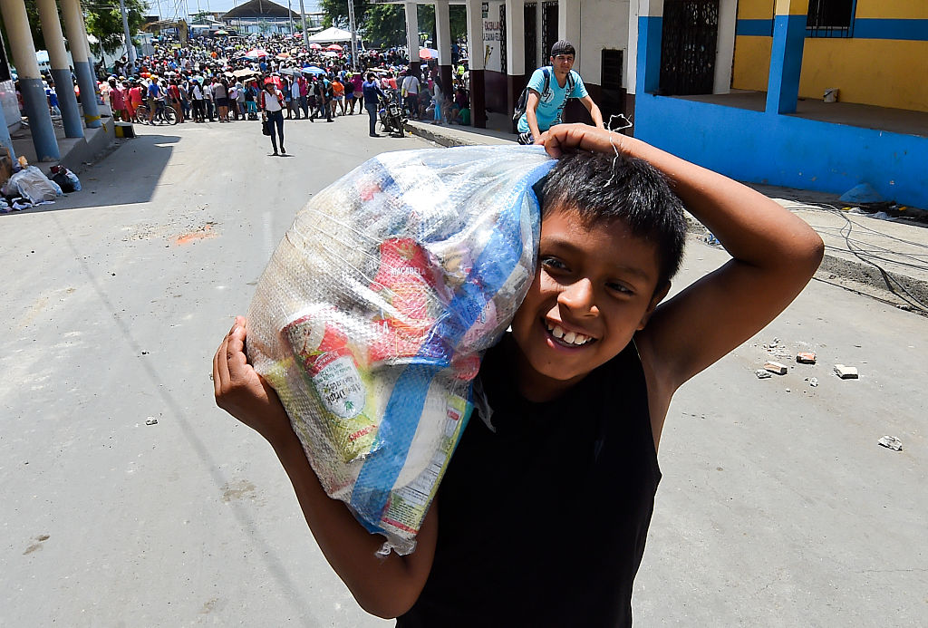 Un niño ecuatoriano sonríe después de recibir provisiones de comida en Manta, Ecuador. El espíritu del pueblo ecuatoriano está más fuerte que nunca tras el devastador terremoto del 16 de abril. (Crédito: LUIS ACOSTA/AFP/Getty Images)