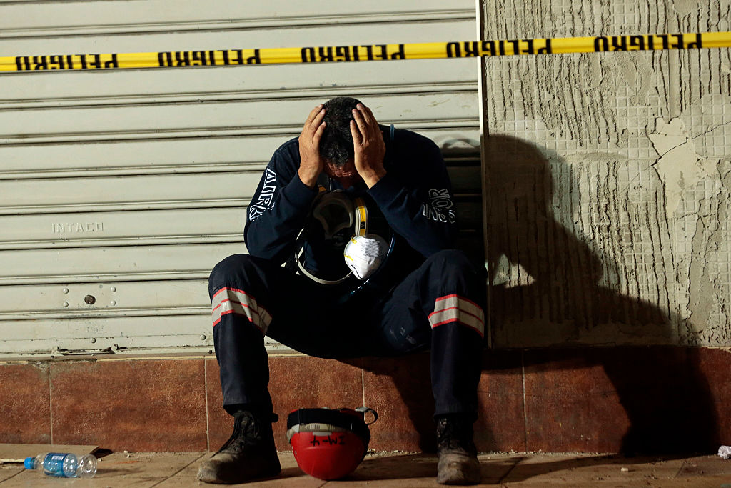 A rescuer takes a break after helping in the search for earthquake victims in Manta on April 20, 2016. The death toll from Ecuador's earthquake was set to rise sharply after authorities warned that 1,700 people were still missing and anger gripped families of victims trapped in the rubble. A 6.1-magnitude earthquake struck off the coast of Ecuador Wednesday, sowing new panic four days after a more powerful quake killed more than 525 people, with hundreds still missing. / AFP / Juan Cevallos (Photo credit should read JUAN CEVALLOS/AFP/Getty Images)