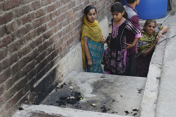 Niñas observan el lugar donde Zeeat fue quemada viva por su propia madre (Crédito: ARIF ALI/AFP/Getty Images)