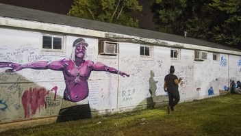 Una persona que lee los mensajes escritos en la pared junto a la tienda donde Alton Sterling murió a tiros el 6 de julio de 2016, en Baton Rouge, Louisiana. Crédito: Mark Wallheiser / Getty Images.