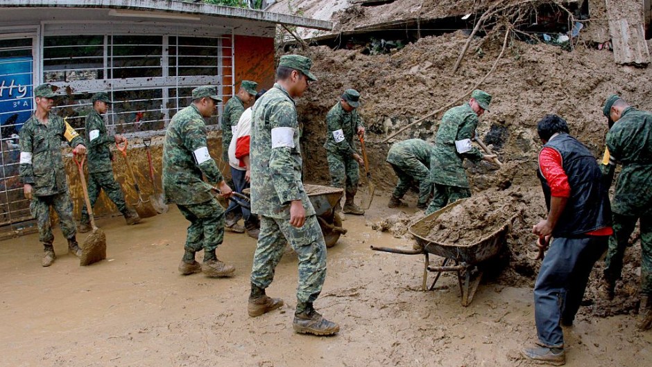Mexican soldiers help dig out damaged homes in Xalapa community, Veracruz, Mexico on August 6, 2016. Six people died in the eastern Mexican state of Veracruz after their homes were buried by landslides following heavy rains from Earl, which reached Mexican territory on Thursday as a tropical storm and Saturday was only a remnant low pressure. / AFP / EDUARDO MURILLO (Photo credit should read EDUARDO MURILLO/AFP/Getty Images)