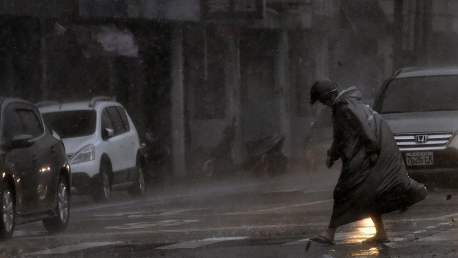 TOPSHOT - A man walks during a storm in Xindian district, New Taipei City, as Typhoon Megi hit eastern Taiwan on September 27, 2016. Taiwan went into shutdown on September 27 as the island faces its third typhoon in two weeks, with thousands evacuated, schools and offices closed across the island and hundreds of flights disrupted. / AFP / SAM YEH (Photo credit should read SAM YEH/AFP/Getty Images)