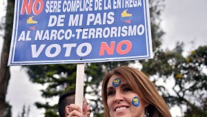 A woman holds a sign reading "I won't be accomplice of the handing of my country to drug-terrorism. I vote No" during a motorcade ahead of Sunday referendum in Bogota, on October 1, 2016. Colombians will vote a referendum Sunday on whether to ratify a historic peace accord to end the 52-year war between the state and the communist FARC rebels. The accord will effectively end what is seen as the last major armed conflict in the Western Hemisphere. The war has killed hundreds of thousands of people and displaced millions. / AFP / GUILLERMO LEGARIA (Photo credit should read GUILLERMO LEGARIA/AFP/Getty Images)