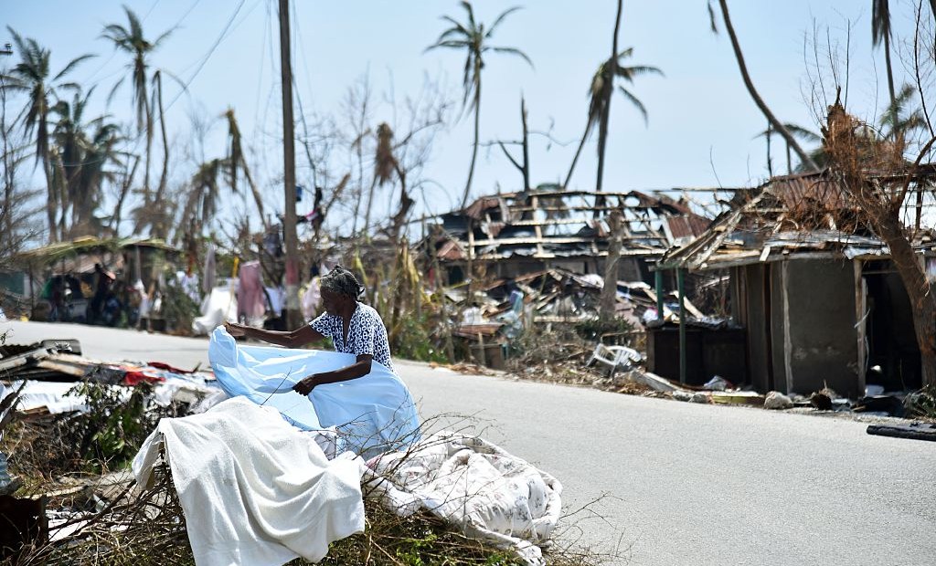 A woman displays her clothes in front of her destroyed house in Les Cayes, Haiti on October 10, 2016, following the passage of Hurricane Matthew. Haiti faces a humanitarian crisis that requires a "massive response" from the international community, the United Nations chief said , with at least 1.4 million people needing emergency aid following last week's battering by Hurricane Matthew. / AFP / HECTOR RETAMAL (Photo credit should read HECTOR RETAMAL/AFP/Getty Images)