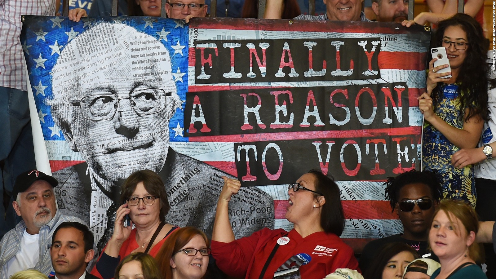 Seguidores de Bernie Sanders sostienen un afiche durante un evento de campaña del excandidato demócrata.