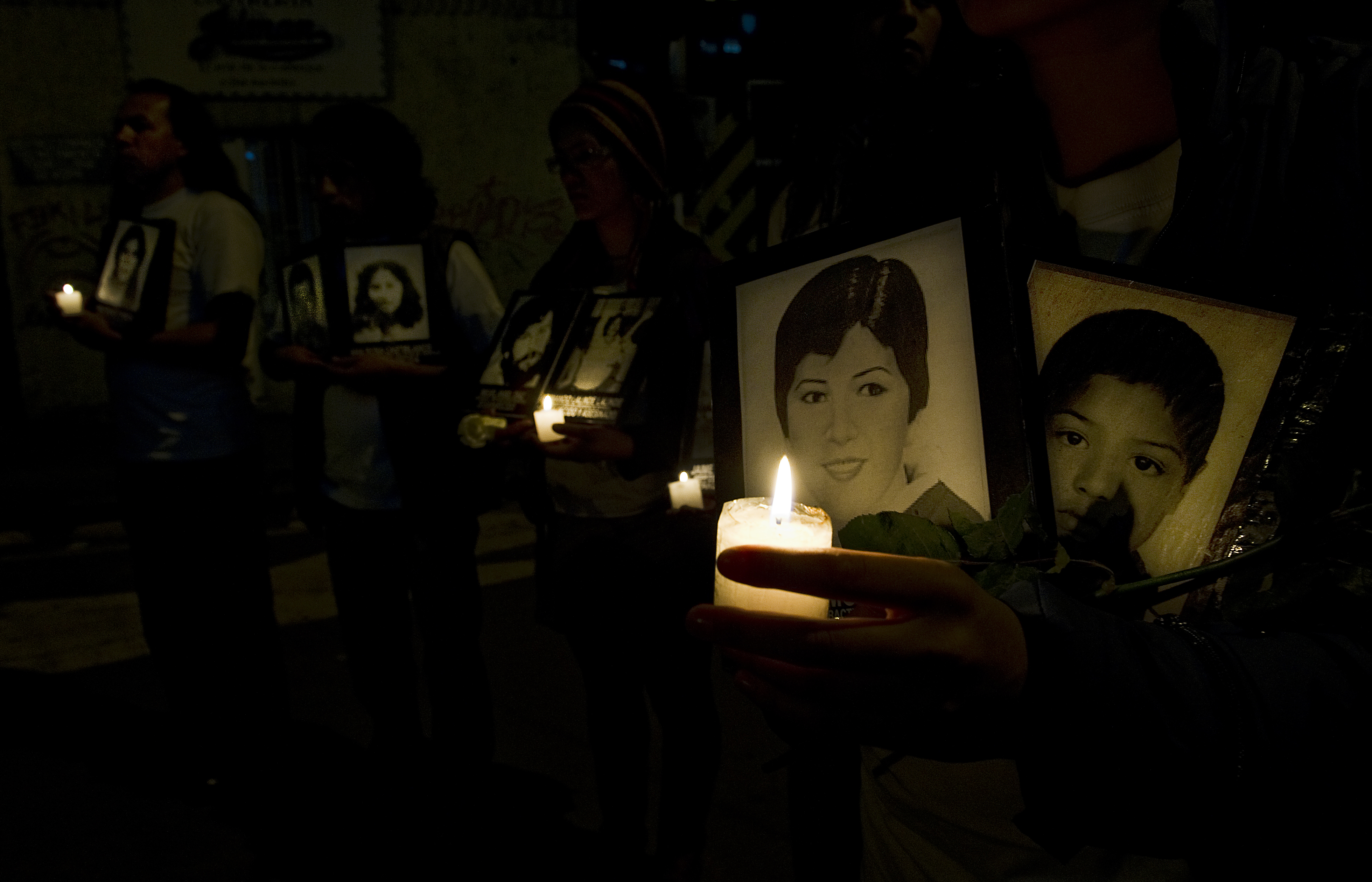 Relatives of missing persons in Colombia hold photographs and candles during a protest in Bogota on May 26, 2011. The drama of enforced disappearance in Colombia has reached numbers that the representative in Colombia of the United Nations High Commissioner for Human Rights, Christian Salazar, described as "chilling". At least 26,500 cases have been reported to the prosecutor. AFP PHOTO/Luis Acosta (Photo credit should read LUIS ACOSTA/AFP/Getty Images)