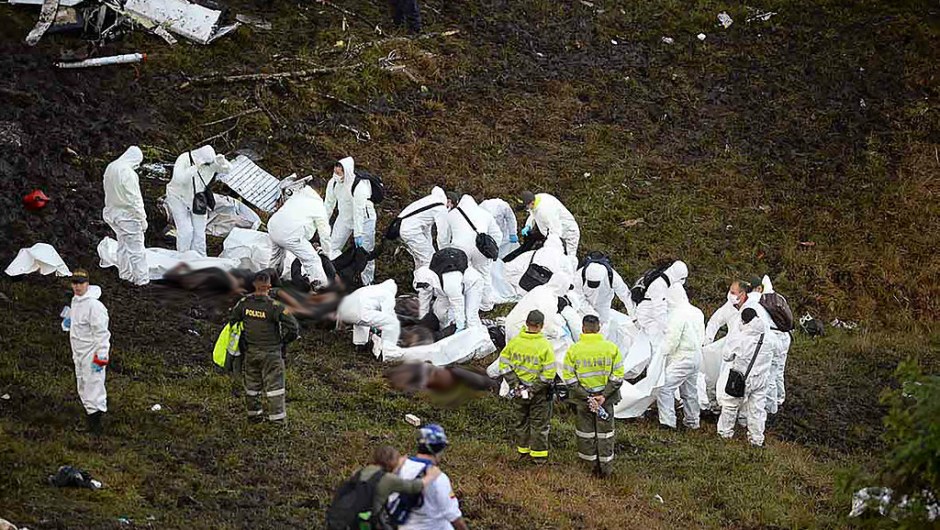 TOPSHOT - EDITORS NOTE: Graphic content / Members of the forensics team recover the bodies of victims of the LAMIA airlines charter plane crash in the mountains of Cerro Gordo, municipality of La Union, on November 29, 2016. A charter plane carrying the Chapecoense Real football team crashed in the mountains in Colombia late Monday, killing as many as 75 people, officials said. / AFP / RAUL ARBOLEDA (Photo credit should read RAUL ARBOLEDA/AFP/Getty Images)