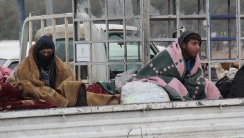Syrians being evacuated from Aleppo are seen in the back of a pick up truck as it drives through a rebel-held territory near Rashidin, west of the embattled city, on December 22, 2016. Convoys carried opposition fighters out of the last rebel pocket of Aleppo in the final phase of an evacuation clearing the way for Syria's army to retake the city. As part of the Aleppo evacuation deal, it was agreed that some residents would be allowed to leave Fuaa and Kafraya, two Shiite-majority villages in northwestern Syria that are under siege by the Sunni Muslim rebels. / AFP / Omar haj kadour (Photo credit should read OMAR HAJ KADOUR/AFP/Getty Images)