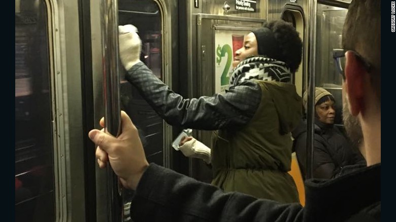 Una pasajera ayuda a remover el graffiti del tren. 