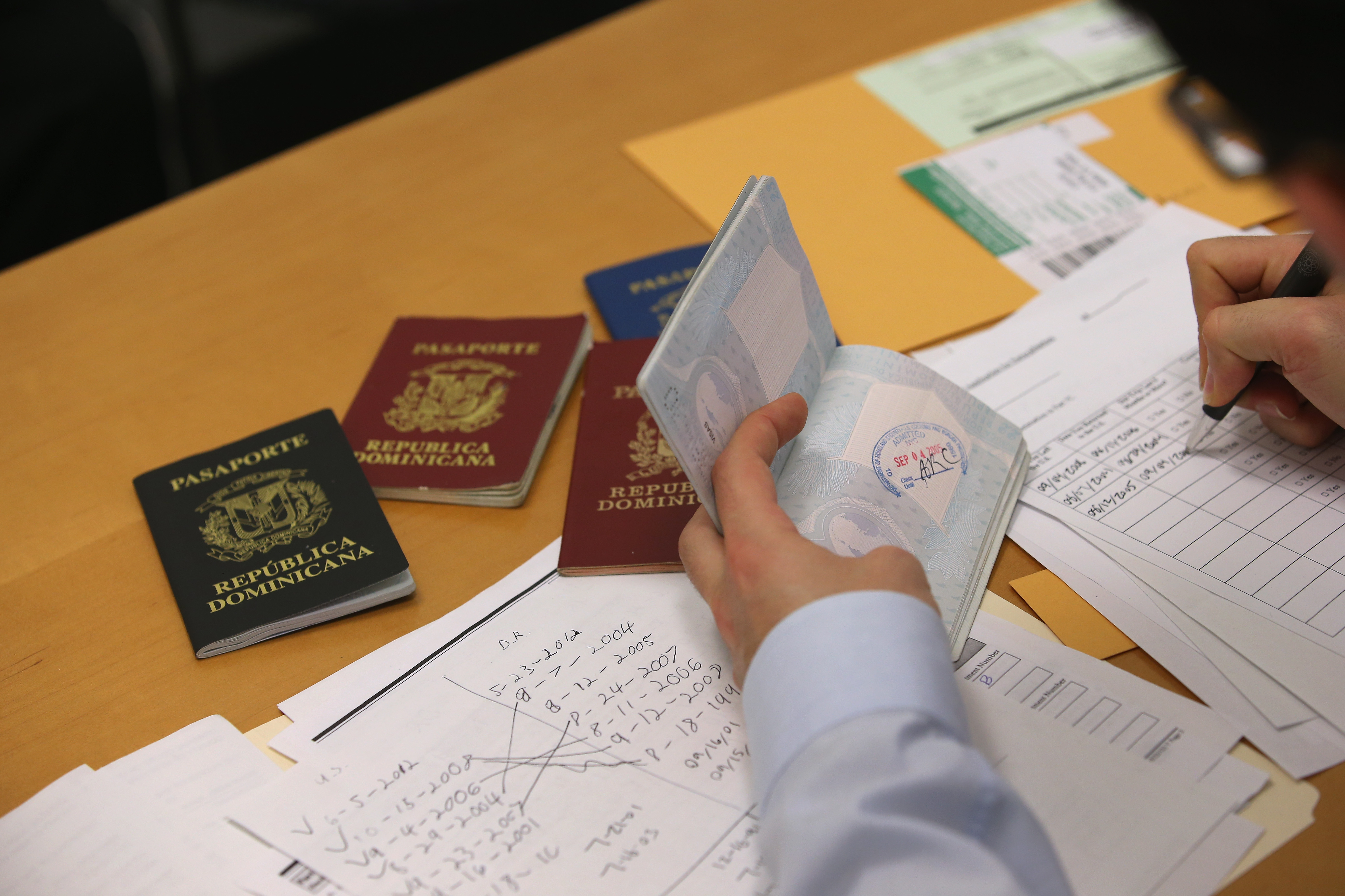 Un abogado de inmigración selecciona pasaportes dominicanos tanto al día como vencidos el pasado 31 de enero en Nueva York. (Crédito: John Moore/Getty Images)