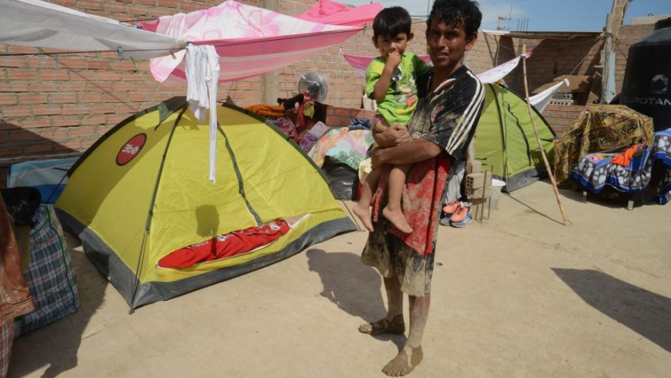 Families set up tents in the town of Huarmey, 300 kilometres north of Lima, where the ground was covered on March 19, 2017 with several centimetres of mud and silt after a flash flood hit the evening before. The El Nino climate phenomenon is causing muddy rivers to overflow along the entire Peruvian coast, isolating communities and neighbourhoods. Thousands have been affected since January, and 72 people have died. Most cities face water shortages as water lines have been compromised by mud and debris. / AFP PHOTO / CRIS BOURONCLE (Photo credit should read CRIS BOURONCLE/AFP/Getty Images)
