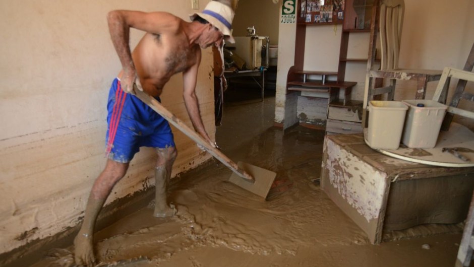Local residents of the town of Huarmey, 300 kilometres north of Lima, try to get rid of muddy water on March 19, 2017 after a flash flood hit the evening before. The El Nino climate phenomenon is causing muddy rivers to overflow along the entire Peruvian coast, isolating communities and neighbourhoods. Thousands have been affected since January, and 72 people have died. Most cities face water shortages as water lines have been compromised by mud and debris. / AFP PHOTO / CRIS BOURONCLE (Photo credit should read CRIS BOURONCLE/AFP/Getty Images)
