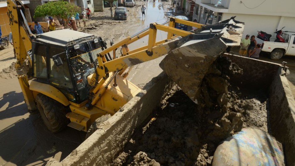 A bulldozer removes mud in the town of Huarmey, 300 kilometres north of Lima, on March 19, 2017 after a flash flood hit the evening before. The El Nino climate phenomenon is causing muddy rivers to overflow along the entire Peruvian coast, isolating communities and neighbourhoods. Thousands have been affected since January, and 72 people have died. Most cities face water shortages as water lines have been compromised by mud and debris. / AFP PHOTO / CRIS BOURONCLE (Photo credit should read CRIS BOURONCLE/AFP/Getty Images)