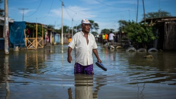 TOPSHOT - A local resident wades through water on a street in the "El Indio" settlement on the outskirts of Piura, in northern Peru, on March 23, 2017. The El Nino climate phenomenon is causing muddy rivers to overflow along the entire Peruvian coast, isolating communities and neighbourhoods. / AFP PHOTO / Ernesto BENAVIDES (Photo credit should read ERNESTO BENAVIDES/AFP/Getty Images)