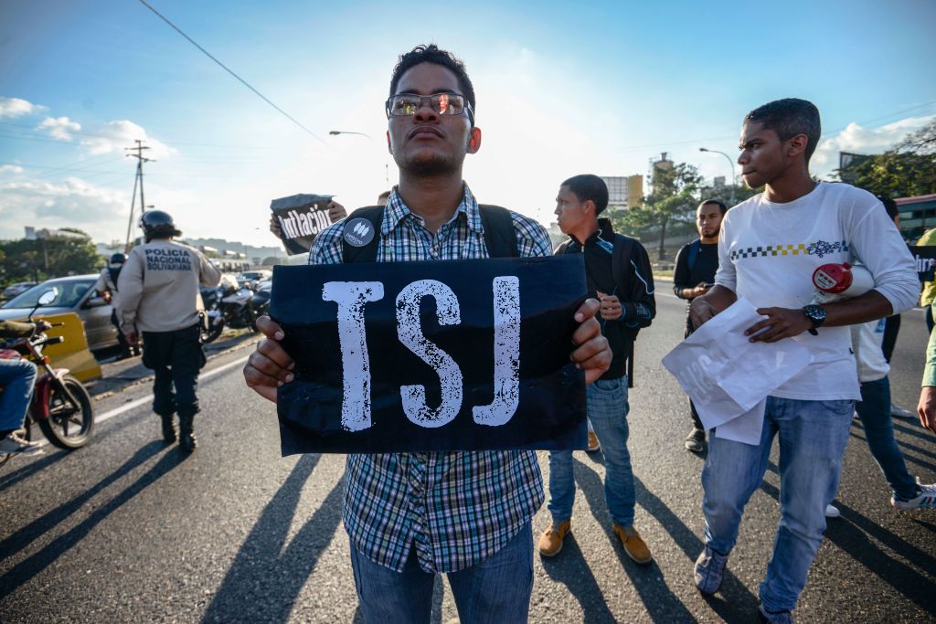 Students take part in a protest against Venezuelan President Nicola Maduro on the main highway in Caracas on March 30, 2017. Venezuela's Supreme Court took over legislative powers Wednesday from the opposition-majority National Assembly, whose speaker accused leftist President Nicolas Maduro of staging a "coup." / AFP PHOTO / Juan BARRETO (Photo credit should read JUAN BARRETO/AFP/Getty Images)