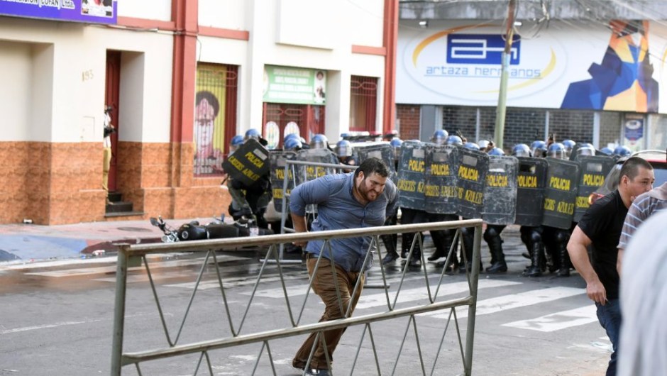 Riot police crack down on a protest against the approval of a constitutional amendment for presidential reelection, outside Congress in Asuncion, on March 31, 2017. Ruling Colorado party senators and their allies, in a so-called "parallel Senate", unexpectedly approved an amendment Friday that would allow President Horacio Cartes to run for reelection in 2018, triggering protests that led to clashes between opposition demonstrators and the police. / AFP PHOTO / NORBERTO DUARTE (Photo credit should read NORBERTO DUARTE/AFP/Getty Images)