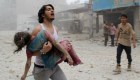 TOPSHOTS A man carries a young girl who was injured in a reported barrel-bomb attack by government forces on June 3, 2014 in Kallaseh district in the northern city of Aleppo. Some 2,000 civilians, including more than 500 children, have been killed in regime air strikes on rebel-held areas of Aleppo since January, many of them in barrel bomb attacks. AFP PHOTO / BARAA AL-HALABIBARAA AL-HALABI/AFP/Getty Images