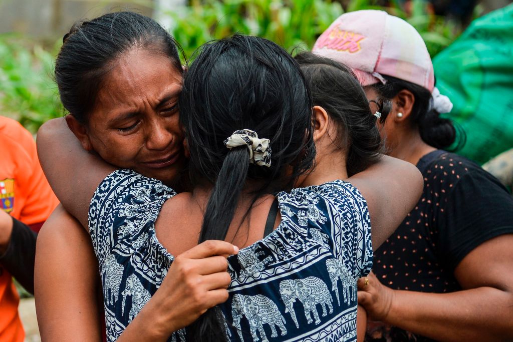 A woman cries when she is reunited with her family amidst the rubble left by mudslides following heavy rains in Mocoa, Putumayo department, southern Colombia on April 2, 2017. The death toll from a devastating landslide in the Colombian town of Mocoa stood at around 200 on Sunday as rescuers clawed through piles of muck and debris in search of survivors. / AFP PHOTO / LUIS ROBAYO (Photo credit should read LUIS ROBAYO/AFP/Getty Images)