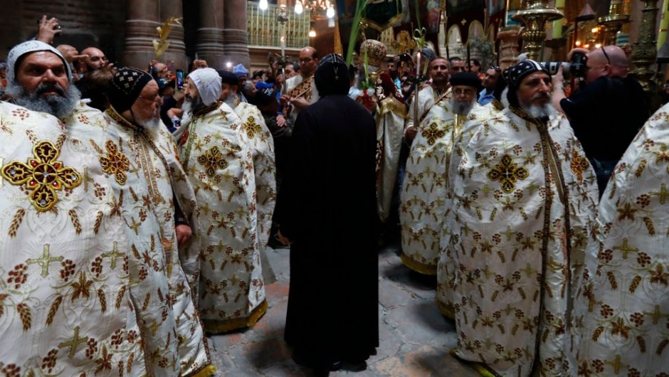 Egyptian Coptic priests encircle the aedicule during the Palm Sunday Easter procession at the Church of the Holy Sepulchre in Jerusalem's Old City on April 9, 2017. The ceremony is a landmark in the Roman Catholic calendar, marking the triumphant return of Christ to Jerusalem the week before his death, when a cheering crowd greeted him waving palm leaves. Palm Sunday marks the start of the most solemn week in the Christian calendar. / AFP PHOTO / GALI TIBBON (Photo credit should read GALI TIBBON/AFP/Getty Images)