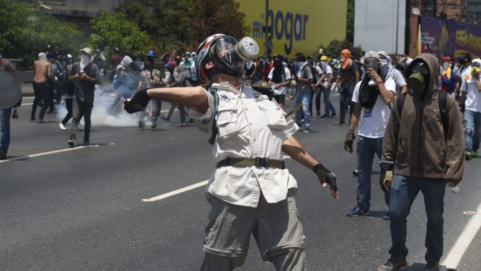 Opposition demonstrators clash with riot police during a march in Caracas on April 26, 2017. Protesters in Venezuela plan a high-risk march against President Maduro Wednesday, sparking fears of fresh violence after demonstrations that have left 26 dead in the crisis-wracked country. The placard reads "Jailed Students and Loose Delinquents" / AFP PHOTO / JUAN BARRETO (Photo credit should read JUAN BARRETO/AFP/Getty Images)