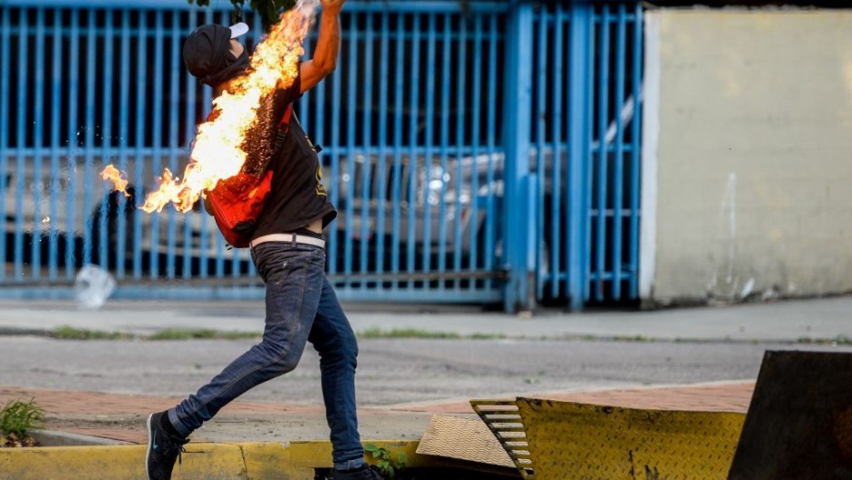 An opposition activist clashes with riot police during a protest against President Nicolas Maduro in Caracas on April 26, 2017. Venezuelan riot police fired tear gas to stop anti-government protesters from marching on central Caracas, the latest clash in a wave of unrest that, up to now, has left 26 people dead. / AFP PHOTO / FEDERICO PARRA (Photo credit should read FEDERICO PARRA/AFP/Getty Images)