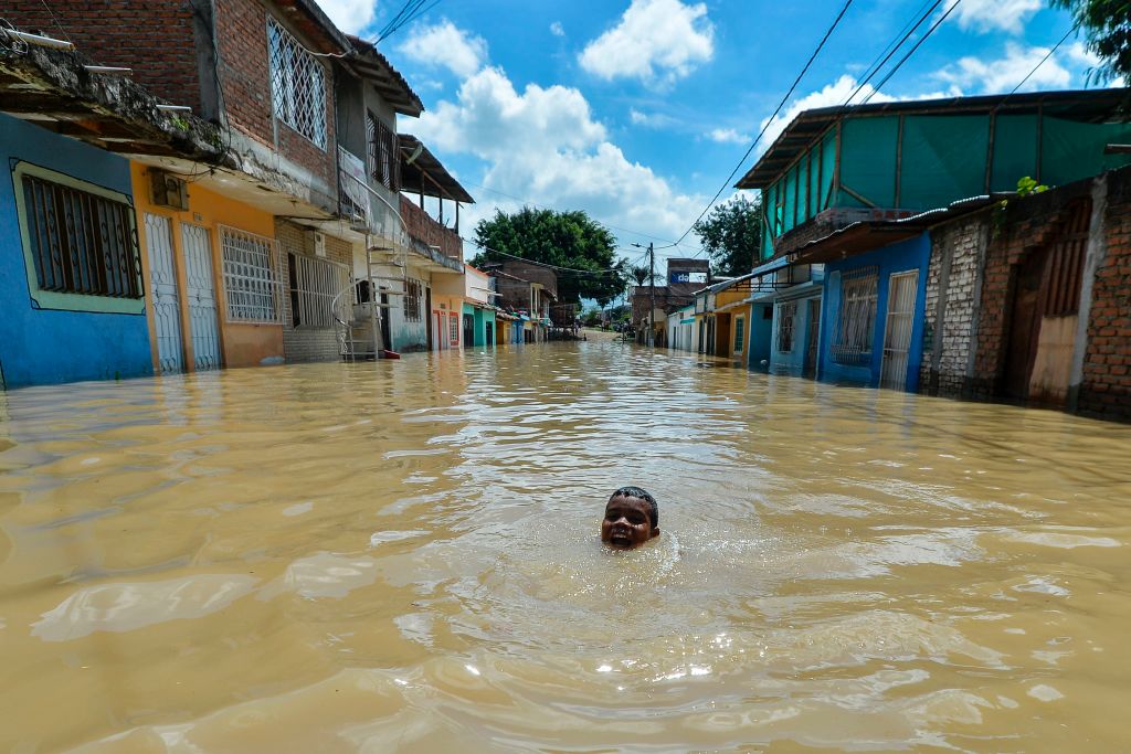 A boy swims in a flooded area of Cali, Colombia, on May 13, 2017 after heavy rains caused the overflowing of the Cauca river. Flooding and mudslides in Colombia have killed several people and affected thousands in the past weeks causing alarm in a country still recovering from recent mudslides that killed hundreds. / AFP PHOTO / LUIS ROBAYO (Photo credit should read LUIS ROBAYO/AFP/Getty Images)