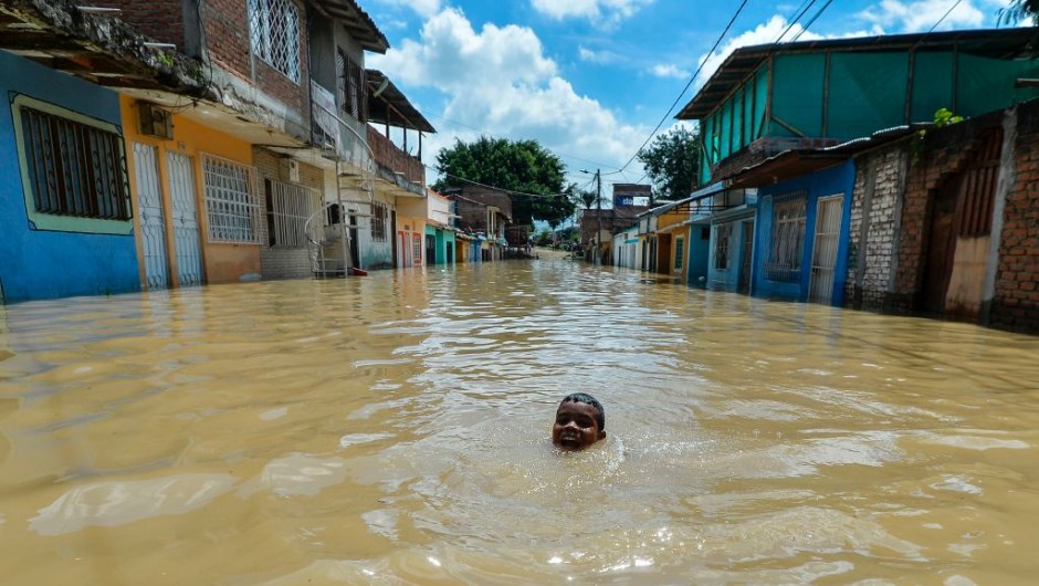 A boy swims in a flooded area of Cali, Colombia, on May 13, 2017 after heavy rains caused the overflowing of the Cauca river. Flooding and mudslides in Colombia have killed several people and affected thousands in the past weeks causing alarm in a country still recovering from recent mudslides that killed hundreds. / AFP PHOTO / LUIS ROBAYO (Photo credit should read LUIS ROBAYO/AFP/Getty Images)