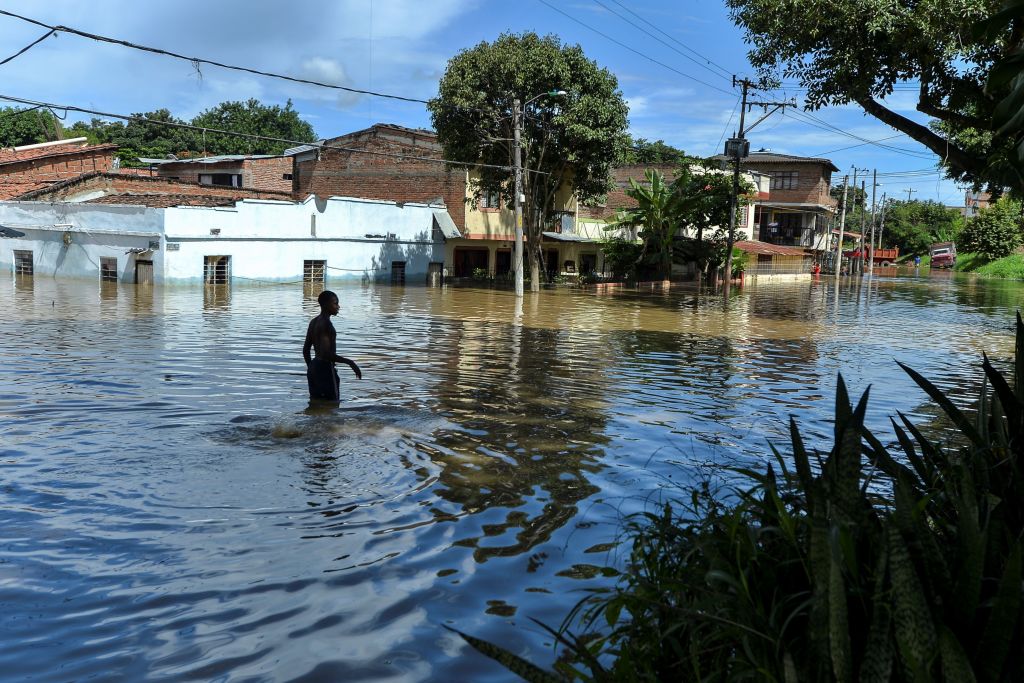 A man wades through the water in a flooded area of Cali, Colombia, on May 13, 2017 after heavy rains caused the overflowing of the Cauca river. Flooding and mudslides in Colombia have killed several people and affected thousands in the past weeks causing alarm in a country still recovering from recent mudslides that killed hundreds. / AFP PHOTO / LUIS ROBAYO (Photo credit should read LUIS ROBAYO/AFP/Getty Images)