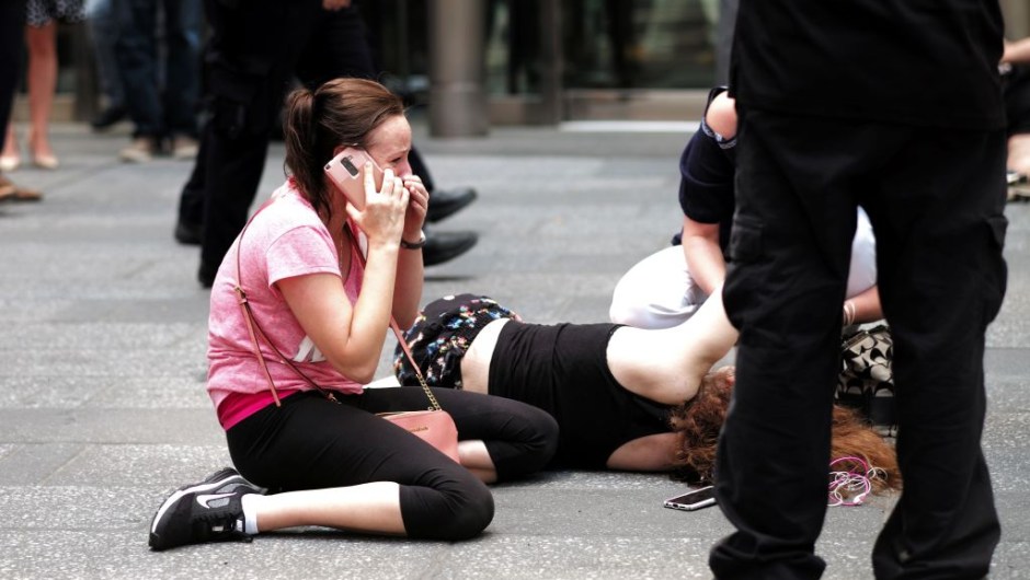 EDITORS NOTE: Graphic content / A woman makes a phone call as others attend to an injured person after a car plunged into them in Times Square in New York on May 18, 2017. A car plowed into a crowd of pedestrians in New York's bustling Times Square, leaving one person dead and at least 19 others injured in what officials said was an accident. / AFP PHOTO / Jewel SAMAD (Photo credit should read JEWEL SAMAD/AFP/Getty Images)