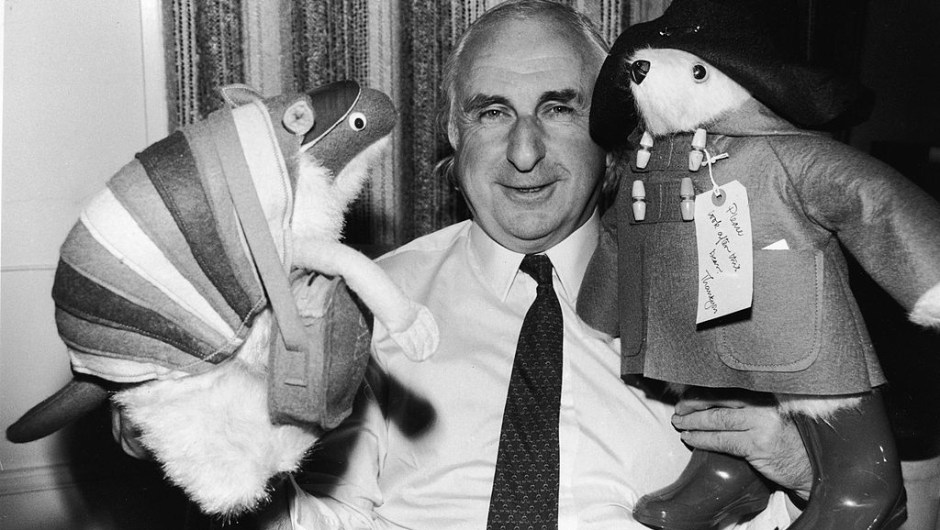 British children's book author Michael Bond stands with stuffed animal toys of his characters Paddington Bear and J.D. Polson the Armadillo, June 27, 1981. (Photo by Larry Ellis/Express Newspapers/Getty Images)