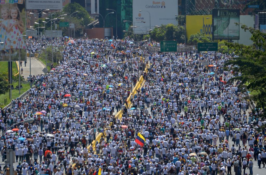 TOPSHOT - Opposition activists march against President Nicolas Maduro's government in Caracas, on May 29, 2017. Demonstrations that got underway in late March have claimed the lives of 59 people, as opposition leaders seek to ramp up pressure on Venezuela's leftist president, whose already-low popularity has cratered amid ongoing shortages of food and medicines, among other economic woes. / AFP PHOTO / LUIS ROBAYO (Photo credit should read LUIS ROBAYO/AFP/Getty Images)