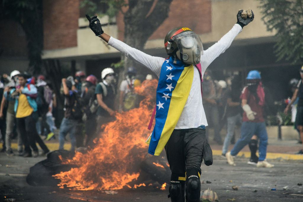 TOPSHOT - Opposition demonstrators clash with riot police in Caracas, on May 31, 2017. Venezuelan authorities on Wednesday began signing up candidates for a planned constitutional reform body, a move that has inflamed deadly unrest stemming from anti-government protests. / AFP PHOTO / FEDERICO PARRA (Photo credit should read FEDERICO PARRA/AFP/Getty Images)