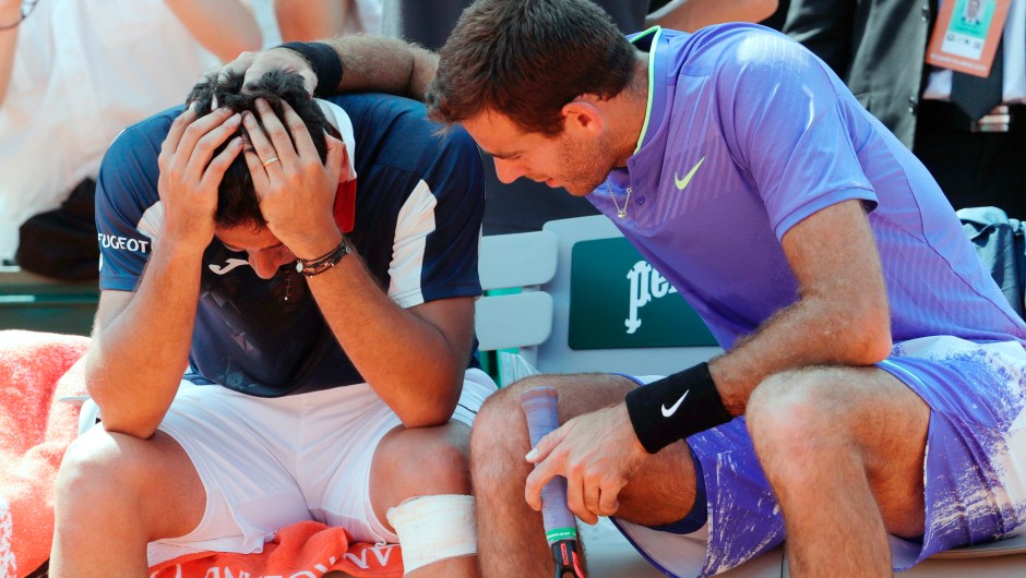 El español Nicolas Almagro (izq.) es consolado por el argentino Juan Martin del Potro después de que tuviera que retirarse por lesión durante su partido de Roland Garros el 1 de junio de 2017 en París. Crédito: aTHOMAS SAMSON / AFP / Getty Images.