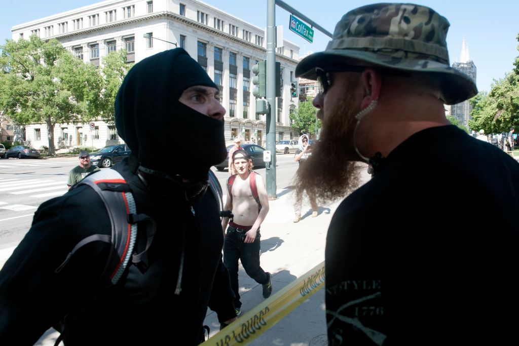 An Antifa demonstrator has a heated exchange with a pro-Trump supporter during the Denver March Against Sharia Law in Denver, Colorado on June 10, 2017. The march was supported by two right-wing groups, The Proud Boys, and Bikers Against Radical Islam. Police kept the counter protestors separated during the rally which was held in front of the Colorado State Capital. The march was one of many held throughout the U.S. opposing Sharia law, and was viewed by many as promoting both Islamophobia and racism. / AFP PHOTO / Jason Connolly (Photo credit should read JASON CONNOLLY/AFP/Getty Images)