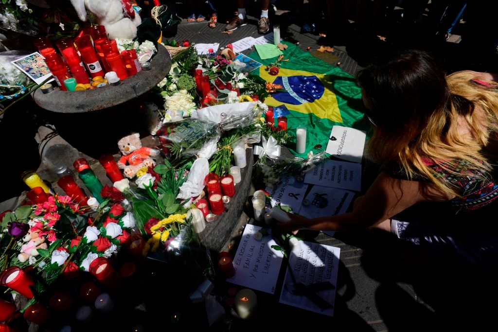 A woman displays a candle next to flowers, messages, stuffed toys and many differents objects for the victims on August 18, 2017 on the spot where yesterday a van ploughed into the crowd, killing 13 persons and injuring over 100 on the Rambla boulevard in Barcelona. Drivers have ploughed on August 17, 2017 into pedestrians in two quick-succession, separate attacks in Barcelona and another popular Spanish seaside city, leaving 13 people dead and injuring more than 100 others. In the first incident, which was claimed by the Islamic State group, a white van sped into a street packed full of tourists in central Barcelona on Thursday afternoon, knocking people out of the way and killing 13 in a scene of chaos and horror. Some eight hours later in Cambrils, a city 120 kilometres south of Barcelona, an Audi A3 car rammed into pedestrians, injuring six civilians -- one of them critical -- and a police officer, authorities said. / AFP PHOTO / JAVIER SORIANO (Photo credit should read JAVIER SORIANO/AFP/Getty Images)