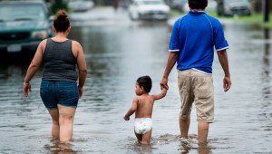People walk through flooded streets as the effects of Hurricane Henry are seen August 26, 2017 in Galveston, Texas.