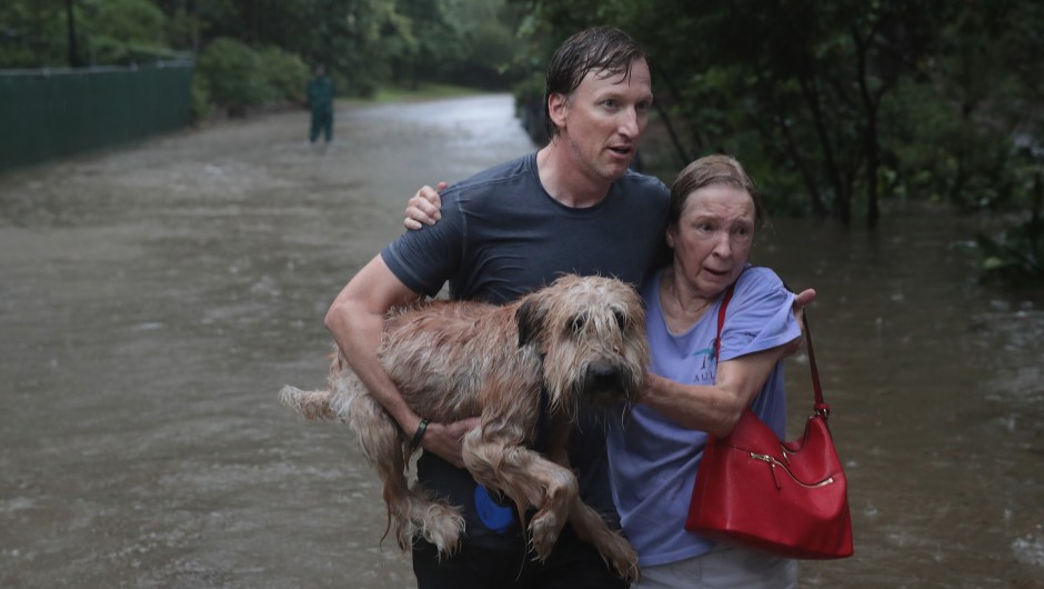 Andrew White (izq.) ayuda a una vecina después de rescatarla de su hogar en su barco en el barrio de River Oaks el 27 de agosto de 2017 en Houston, Texas. Crédito: Scott Olson / Getty Images