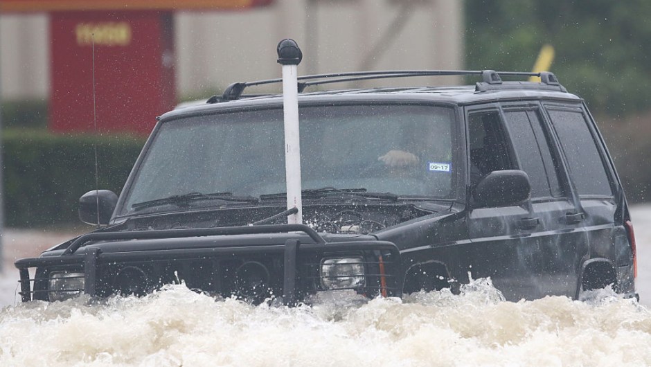 A SUV with a tube connected to his exhaust drives through the flooded waters on Telephone Rd. in Houston on August 27, 2017 as the US fourth city city battles with tropical storm Harvey and resulting floods. / AFP PHOTO / Thomas B. Shea (Photo credit should read THOMAS B. SHEA/AFP/Getty Images)