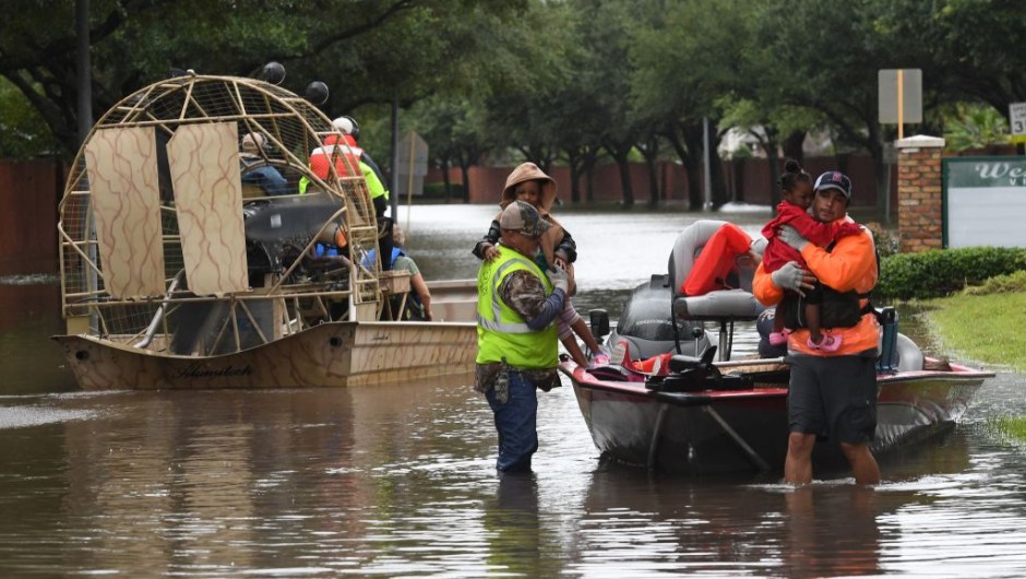 Local residents are evacuated by volunteers from San Antonio, in the Clodine district after Hurricane Harvey caused heavy flooding in Houston, Texas on August 29, 2017. Floodwaters have breached a levee south of the city of Houston, officials said Tuesday, urging residents to leave the area immediately. / AFP PHOTO / MARK RALSTON (Photo credit should read MARK RALSTON/AFP/Getty Images)