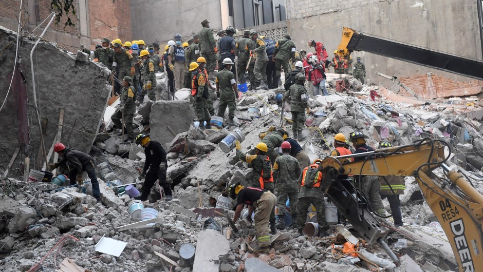 Volunteers remove rubble during the search for survivors in a flattened building in Mexico City on September 20, 2017 after a strong quake hit central Mexico on the eve killing at least 240 people. A powerful 7.1 earthquake shook Mexico City on Tuesday, causing panic among the megalopolis' 20 million inhabitants on the 32nd anniversary of a devastating 1985 quake. / AFP PHOTO / PEDRO PARDO (Photo credit should read PEDRO PARDO/AFP/Getty Images)