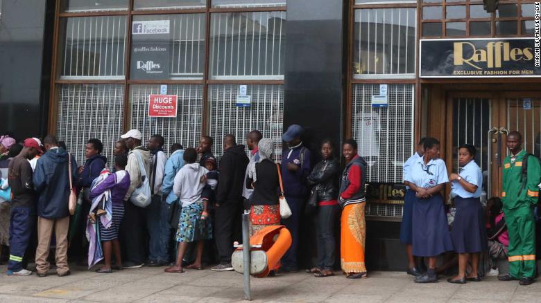 epa06330392 Members of the public wait outside a bank to withdraw cash in Harare, Zimbabwe, 15 November 2017. The Zimbabwe National Army (ZNA) has reportedly taken control over the government of President Robert Mugabe. The army seized the national broadcaster's headquarters (ZBC) on 14 November night, to announce that President Mugabe and his family were safe but without citing their whereabouts. The military denied it staged a coup d'etat. EPA-EFE/AARON UFUMELI