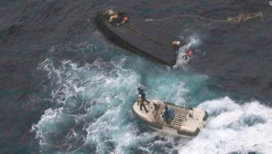 In this Wednesday, Nov. 15, 2017, photo provided by the 9th Regional Japan Coast Guard Headquarters, a boat of the Japan Coast Guard approaches a capsized wooden vessel, top, for a rescue operation in the water off Noto peninsula, northern coast of Japan. Three crew members rescued from the capsized boat are North Koreans, and Tokyo is arranging their return home. The area is a rich fishing ground where poachers from North Korea and China have been spotted. (9th Regional Japan Coast Guard Headquarters via AP)
