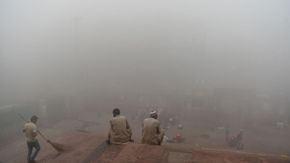 Indian visitors sit on the steps outside Jama Masjid amid heavy smog in the old quarters of New Delhi on November 8, 2017. Delhi shut all primary schools on November 8 as pollution levels hit nearly 30 times the World Health Organization safe level, prompting doctors in the Indian capital to warn of a public health emergency. Dense grey smog shrouded the roads of the world's most polluted capital, where many pedestrians and bikers wore masks or covered their mouths with handkerchiefs and scarves. / AFP PHOTO / Sajjad HUSSAIN (Photo credit should read SAJJAD HUSSAIN/AFP/Getty Images)